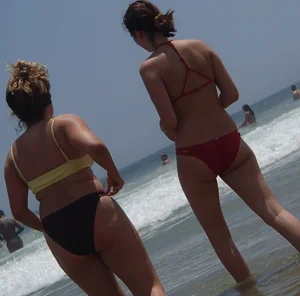 Thick girl and her skinny friend in bikinis at the beach