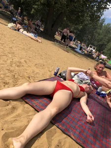 Girl in a Red Swimsuit Lying on a Beach With Spread Legs Photos