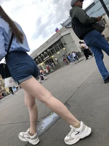 Candid Girl in Blue Denim Shorts and Sneakers Walking Down the Street - Hot Legs Crepshots Collection