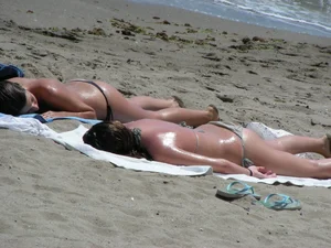 Topless girl with tan lined tits and in a black thong bikini