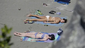 Sexy beach girl laying out in white bikini with nice body