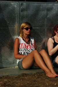 Three girls sitting, one redhead in jeans and a redhead and blonde in shorts