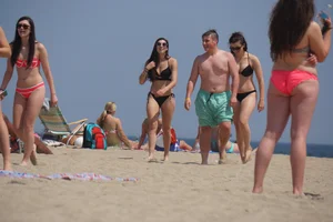 Sexy brunette in bikini playing football on the beach