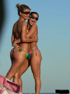 Bunch of sexy babes on the beach topless and in thong bikinis