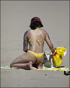 Sexy tattooed beach brunette with a great ass in yellow thong bikini