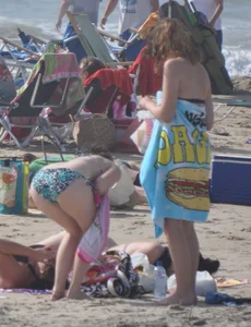 Bikini girls setting up for a day on the beach in their bikinis