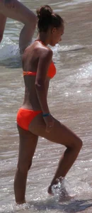 Blonde teen on the beach in orange bikini