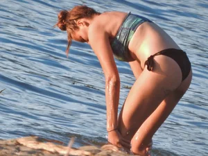 Sexy beach girl in a Nike sports bra and black bikini bottom
