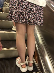 Candid Girl in Sandals and a Dress Standing With Spread Legs On the Subway Escalator