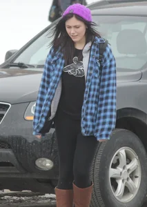 A cute brunette in leggings boots and hat