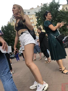 Hot Candid Girl in a Top, Shorts and Sneakers Skinny Legs Closeup Creepshots Gallery on the City Street