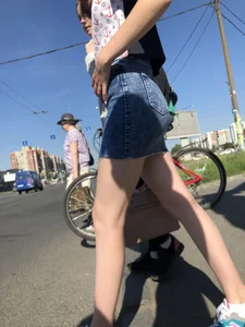 Cute Girl in a Short Denim Skirt Walking on a Street And Waiting on a Crosswalk Gallery