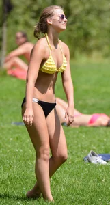 Sexy blonde girl in the park playing volleyball in her skimpy bikini