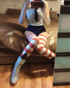 Cosplayer Girl in Knee Socks And Gloves Sitting on Bed Mirror Selfie