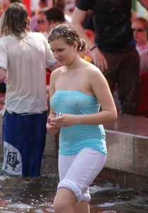 Big boobed girl in blue top with no bra playing in the water