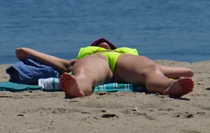 Sexy ass blonde milf on the beach in a thong with cameltoe and bending over