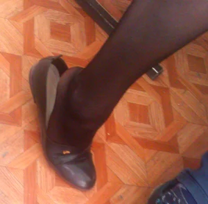 College Teen’s Foot in Black Pantyhose on Tiptoe Closeup With a Flat Partly Taken Off