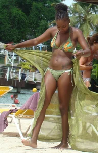 Sexy black babe in various bikinis on the beach while on vacation