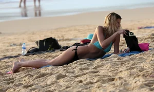 Sexy blonde laying out in black thong bikini