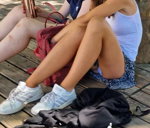 Hot candid girl in a mini-skirt flashing her panties while sitting on the ground creepshot