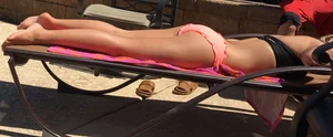 Blonde at the pool and laying out in peach and black bikini combo
