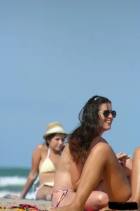 2 topless girls at the beach in thongs
