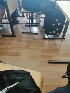 Teen college girl's feet in white socks under desk in class, photos and a video