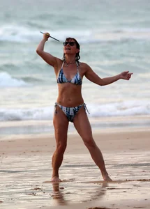 Older lady playing on the beach in her bikini