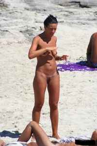 Smoking milf at a nude beach with a hairy pussy