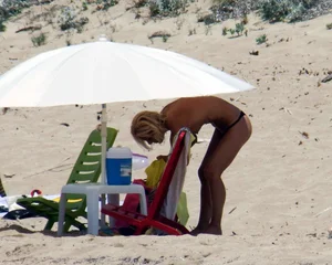 Small boobed topless milf on the beach