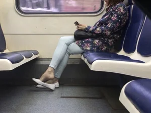 Candid girl dangling her shoe sitting in a public train creepshot
