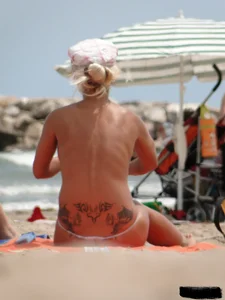 Tattooed blonde with big tits topless and in thong