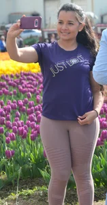 Cute babe in tight leggings taking pictures in flower fields