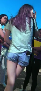 Skinny girl with purple hair in denim shorts