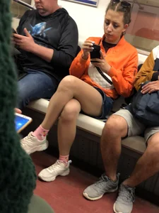 Subway Candid Girl in Denim Shorts and Sneakers Sitting With Crossed Legs in the Train