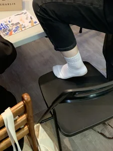 Young Skinny Girl's Legs in Black Jeans And White Socks Foot on the Chair Closeup