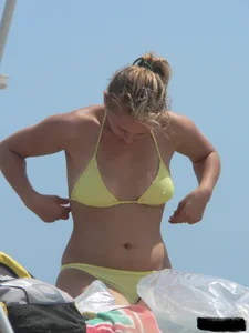 Sexy blonde on the beach in a yellow thong bikini
