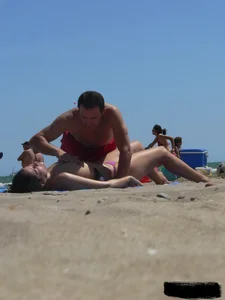 Purple thong topless lady on the beach gets oiled up by her husband