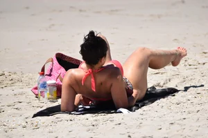 Huge boobed thick brunette babe on the beach in a bikini