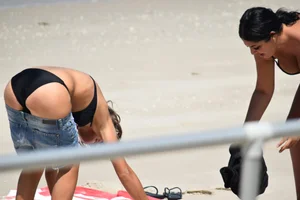 Blonde and brunette on the beach looking sexy in their bikinis