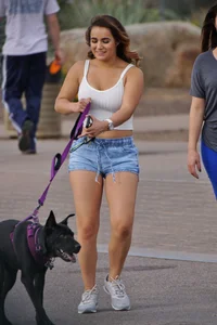 Sexy dog walker in shorts and tank top with friend in blue jeans