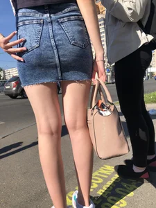 Cute Girl in a Short Denim Skirt Walking on a Street And Waiting on a Crosswalk Gallery