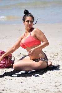 Huge boobed thick brunette babe on the beach in a bikini