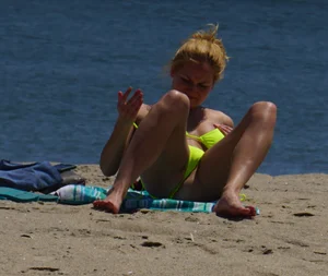 Sexy ass blonde milf on the beach in a thong with cameltoe and bending over