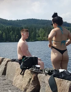 Thick brunette at the lake in a black thong bikini