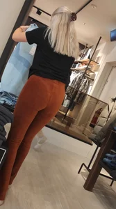 Blonde dutch shop assistent in orange cord leggings