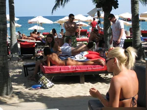 Topless cutie at the beach with a tight little ass in a thong