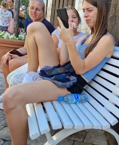 Amazing candid teen in mini shorts sitting on a street bench spreading her legs