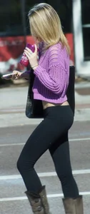 Beautiful skinny blonde in tight leggings and purple crop top showing sexy stomach
