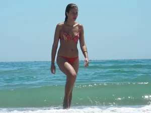 Sexy beach babe in orange thong and floral top
